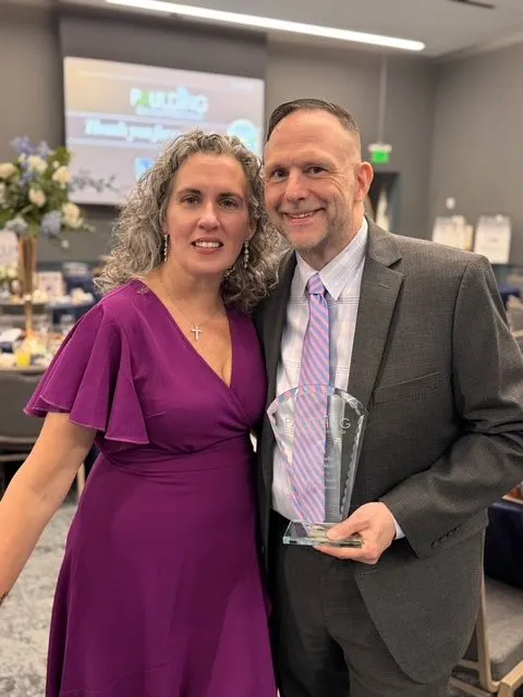 Buffy and Matt Payne celebrating together as Matt holds an award
