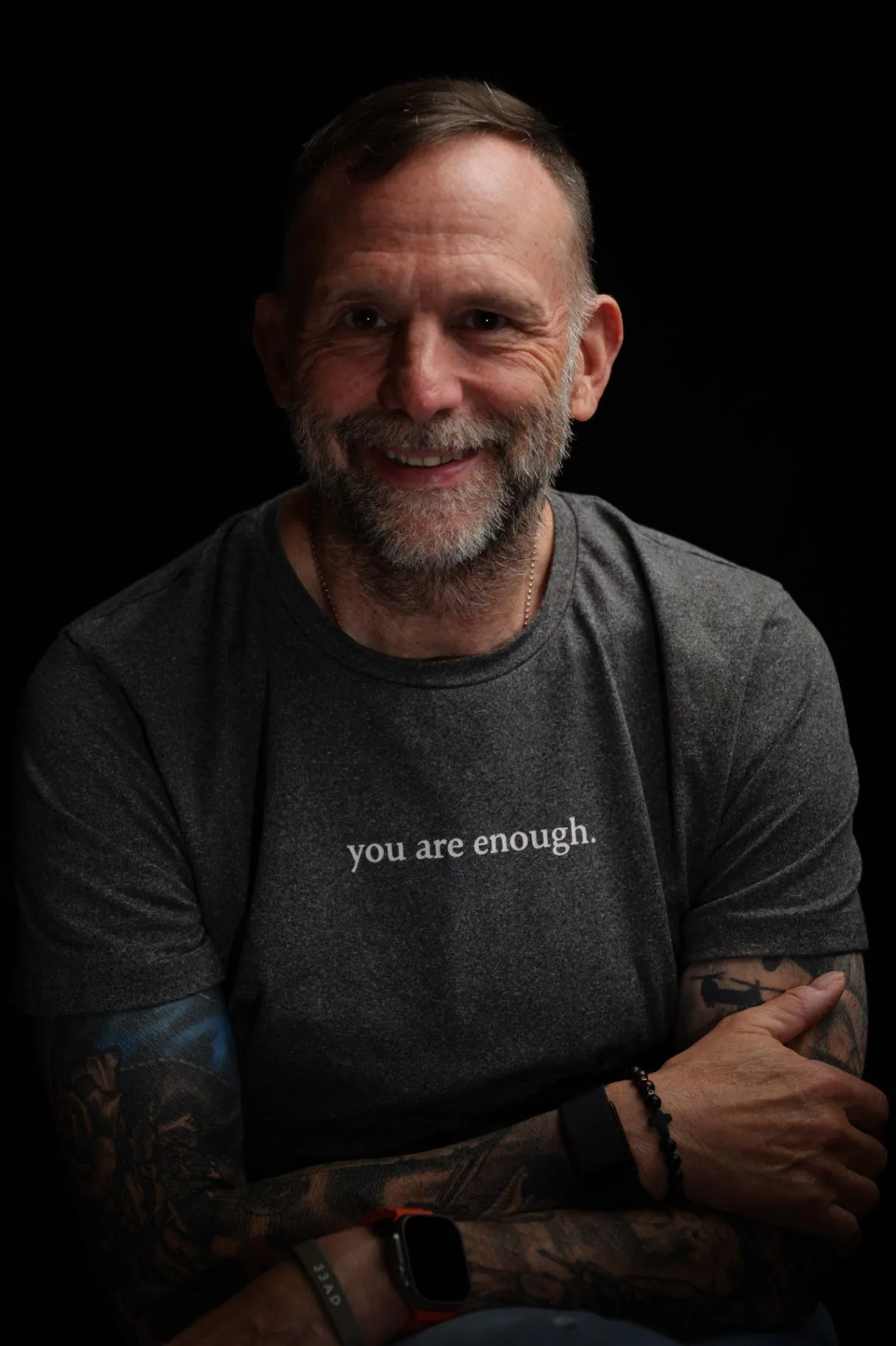 Matt Payne smiling in a gray shirt during a professional portrait session